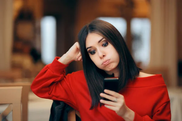 mujer mirando el móvil con mensajes de todos antes de pensar en ella