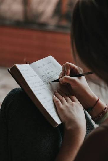Mujer escribiendo  en su diario